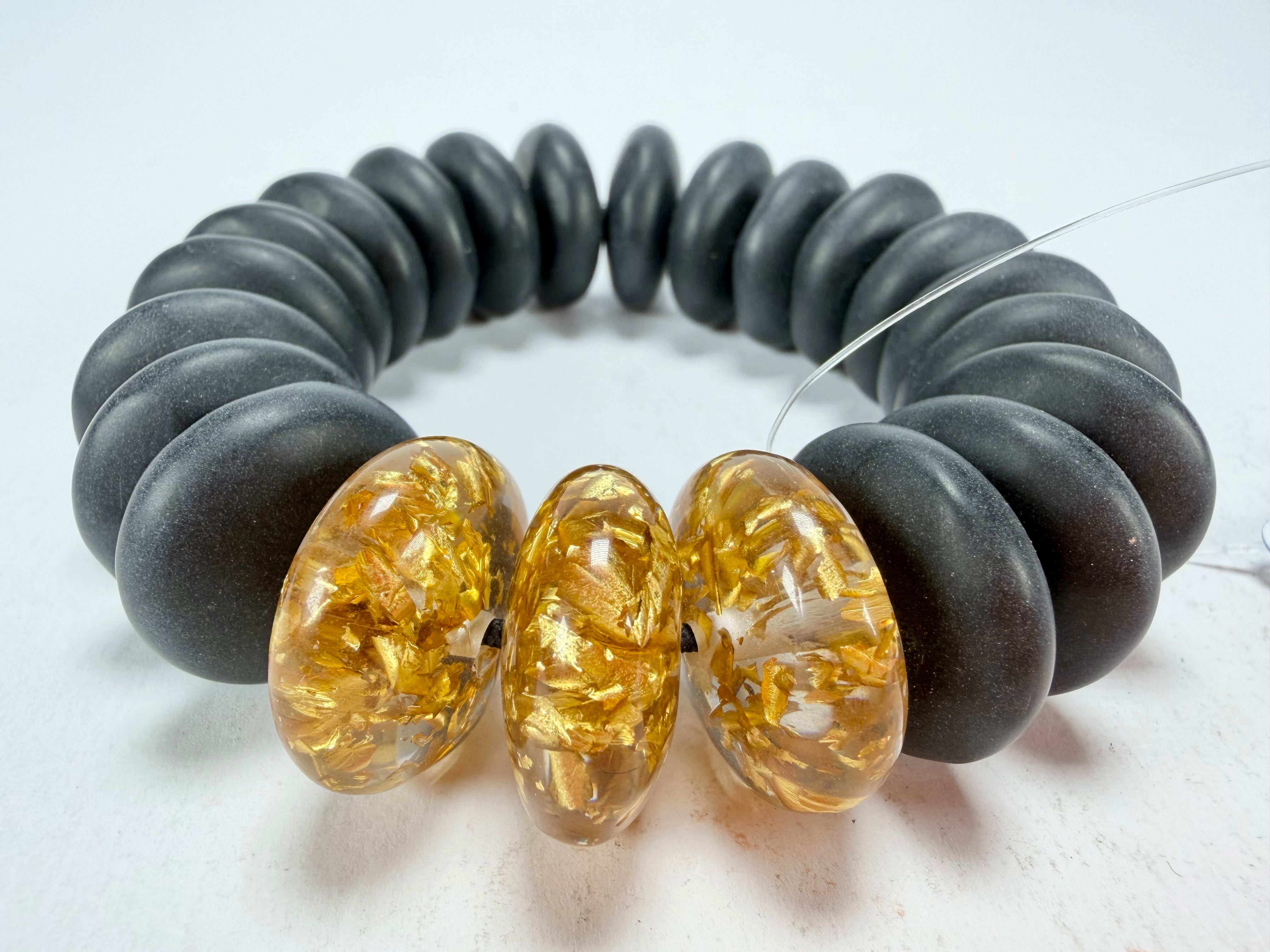Jackie Brazil "Ana" Black Matt & Gold Flakes Mix Elasticated Wheels Resin Bracelet ( B0910 )